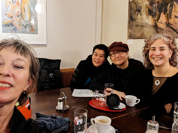 4 Personen sitzen um einen Tisch